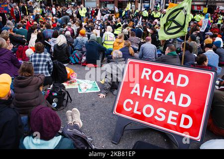 Les membres de la rébellion d'extinction du mouvement activiste du changement climatique (XR) s'assoient sur la route de Trafalgar Square le quatrième jour de la « rébellion internationale » de deux semaines du groupe à Londres, en Angleterre, sur 10 octobre 2019. A l'heure du déjeuner jeudi, la police avait tout sauf contenu les manifestations à Trafalgar Square et sur les routes qui l'entourent, où un nombre important de partisans du XR étaient restés. Une corbillard portant un cercueil pour « notre avenir », qui avait été garée à la sortie de Whitehall de la place depuis lundi, a été enlevée en début d'après-midi. (Photo de David Cliff/NurPhoto) Banque D'Images