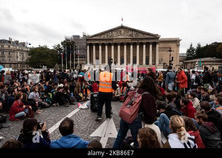 Les activistes de la « rébellion de l'extinction » participent à une assemblée générale impromptue sur le pont de la Concorde face à l'Assemblée nationale tandis que samedi, 12 octobre 2019, pour le dernier jour de la semaine d'action de la « rébellion en octobre » du mouvement environnemental extinction rébellion, Des activistes de l'environnement se sont réunis en dehors de l'Assemblée nationale française pour mener une opération de désobéissance civile afin de bloquer et de sensibiliser le public au changement climatique. La police les a rapidement délogés tout en les gardant sur le pont de la Concorde. (Photo de Samuel Boivin/NurPhoto) Banque D'Images