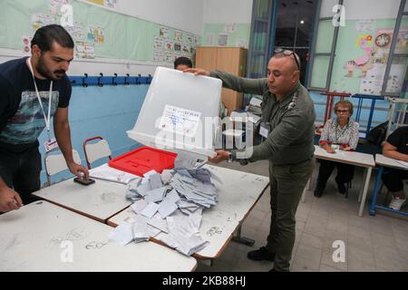 Les membres du personnel de la haute Autorité indépendante pour les élections (ISIE) comptent les bulletins de vote du deuxième tour de l'élection présidentielle tunisienne entre le professeur de droit constitutionnel Kais Saied et l'homme d'affaires Nabil Karoui, après la fermeture des bureaux de vote dans la ville d'Ariana, au nord-est de la Tunisie, sur 13 octobre 2019. (Photo de Chedly Ben Ibrahim/NurPhoto) Banque D'Images