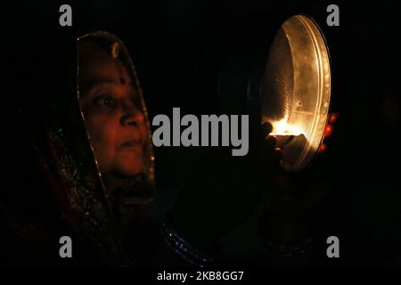 Une femme mariée indienne offre des prières à la lune pour la longue vie de son mari à l'occasion du festival Karva Chauth (jour du mari), à Ajmer, Inde sur 17 octobre 2019. Les femmes mariées hindoues observent Karva Chauth en jeûnant et en offrant des prières à la recherche du bien-être, de la prospérité et de la longévité de leurs maris. (Photo par STR/NurPhoto) Banque D'Images