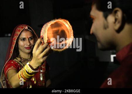 Une femme mariée indienne offre des prières à la lune pour la longue vie de son mari à l'occasion du festival Karva Chauth (jour du mari), à Beawar, Inde sur 17 octobre 2019. Les femmes mariées hindoues observent Karva Chauth en jeûnant et en offrant des prières à la recherche du bien-être, de la prospérité et de la longévité de leurs maris. (Photo par STR/NurPhoto) Banque D'Images