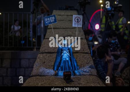 Une figure portant le masque Guy Fawkes et tenant des pancartes est vue lors d'une manifestation anti-gouvernementale à Hong Kong, en Chine, au 19 octobre 2019. Des manifestants pro-démocratie sont descendus dans les rues de Hong Kong depuis des mois du gouvernement. (Photo de Vernon Yuen/NurPhoto) Banque D'Images