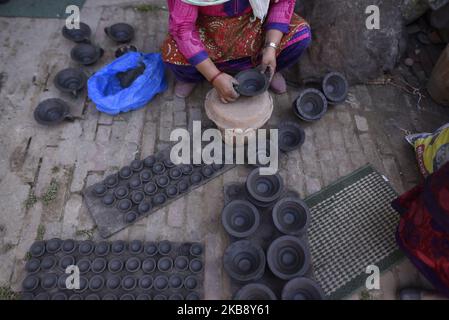 Une femme qui fait des lampes en terre battue pour le prochain Tihar ou Deepawali Festival sur son atelier à la place de la poterie, Bhaktapur, Népal mardi, 22 octobre 2019. Le potier népalais travaille sur son industrie traditionnelle de la poterie à petite échelle à Bhaktapur, au Népal. Bhaktapur est une ancienne ville de la vallée de Katmandou et est classée au patrimoine mondial de l'UNESCO pour sa culture riche, ses temples et ses œuvres d'art en bois, métal et pierre. (Photo de Narayan Maharajan/NurPhoto) Banque D'Images