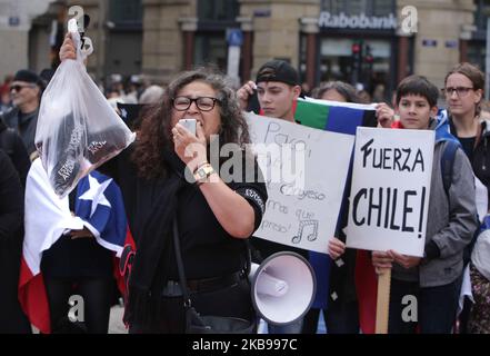 Des membres de la Communauté chilienne protestent sur la place du Dam à 26 octobre 2019, à Amsterdam, aux pays-Bas. Le président Sebastian Piñera a annoncé des mesures visant à améliorer les inégalités sociales, mais les syndicats ont appelé à une grève nationale et des manifestations massives se poursuivent alors que le nombre de morts atteint 18. Les revendications sous-jacentes aux manifestations comprennent des questions comme les soins de santé, le système de retraite, la privatisation de l'eau, les transports publics, l'éducation, mobilité sociale et corruption. (Photo de Paulo Amorim/NurPhoto) Banque D'Images