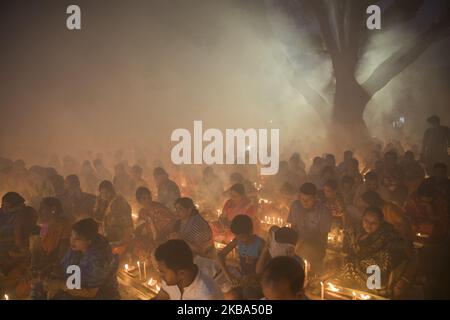 Des milliers de dévotés hindous sont assis sur le sol pour adorer avec des lumières et prier Dieu devant Shri Shri Lokanath Brahmachar Ashram et pendant leur programme à jeun appelé Kartik Brati ou Rakher Upobash à Baradi, Narayangonj, Bangladesh sur 5 novembre 2019. Lokenath Brahmachari, qui s'appelle Baba Lokenath, était un saint hindou et philosophe datant de 18th ans au Bengale. (Photo d'Ahmed Salahuddin/NurPhoto) Banque D'Images