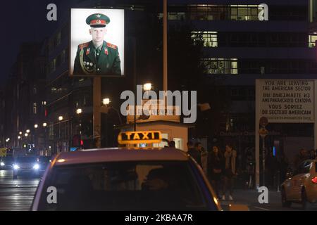 Un portrait d'un soldat russe est illuminé à l'ancien Checkpoint Charlie, où les chars américains et soviétiques se sont affrontés au début de la Guerre froide, deux jours avant le prochain anniversaire de la chute du mur de Berlin en 30th. Le mur de Berlin a divisé la capitale allemande de 1961 à 1989. Checkpoint Charlie était un point de passage principal au mur du secteur américain de Berlin-Ouest au secteur russe de Berlin-est. Jeudi, 7 novembre 2019, à Berlin, en Allemagne. (Photo par Artur Widak/NurPhoto) Banque D'Images