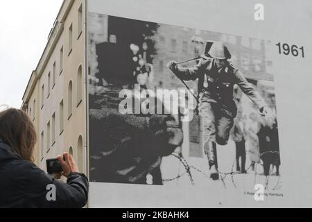 Une dame prend la photo d'une image emblématique de Hans Konrad Schumann, un garde-frontière est-allemand qui a fait défection en Allemagne de l'Ouest lors de la construction du mur de Berlin en 1961, voir sur le bâtiment près de l'endroit où le mur de Berlin était autrefois situé à Bernauer Strasse, À la veille du prochain anniversaire de la chute du mur de Berlin en 30th. Samedi, 9 novembre 2019, à Berlin, en Allemagne. (Photo par Artur Widak/NurPhoto) Banque D'Images