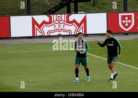 Cristiano Ronaldo (R), l'avant-projet portugais, et Joao Cancelo, le défenseur du Portugal, clavardent lors d'une session d'entraînement au camp d'entraînement de Cidade do Futebol (ville de football) à Oeiras, au Portugal, sur 12 novembre 2019, avant le match de qualification de l'UEFA POUR L'EURO 2020 contre la Lituanie. (Photo par Pedro Fiúza/NurPhoto) Banque D'Images