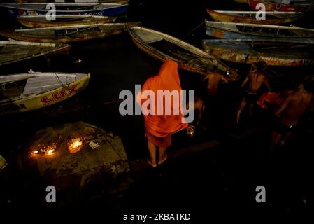 Les dévotés hindous se baignent sur le fleuve Ganga le jour de Dev Deepawali à Varanasi, Inde, 12 novembre 2019. Dev Deepawali est le festival de Kartik Purnima, célébré à Varanasi, Inde. Il est célébré après 15 jours du festival Diwali. Les gens louent les lampes en terre sur tous les ghats de la rivière Ganga pendant le festival Dev Deepawali à Varanasi, Inde. (Photo par Indranil Aditya/NurPhoto) Banque D'Images