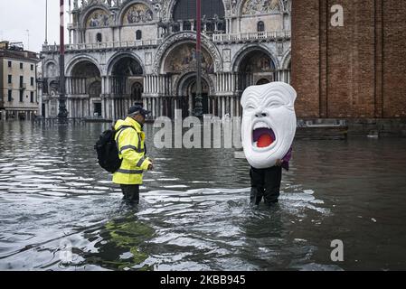Un artiste local avec 'il Grido di Venezia' sur son dos tente de traverser la Piazza San Marco frappée par une vague exceptionnelle de haute eau de 155cm, Venise, sur 17 novembre 2019 (photo de Roberto Silvino/NurPhoto) Banque D'Images