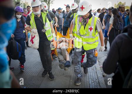 Les volontaires portent un manifestant anti-gouvernement affecté par des gaz lacrymogènes lancés par des policiers anti-émeutes des enfants lors d'une manifestation à Santiago, au Chili, au 31 octobre 2019. (Photo de Jerez Gonzalez/NurPhoto) Banque D'Images