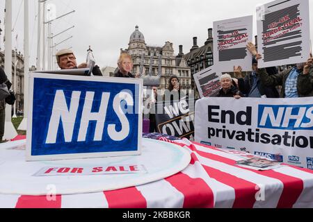 Les manifestants portant des masques de Donald Trump et Boris Johnson ainsi que les militants pour le maintien du National Health Service (NHS) sont réunis devant les chambres du Parlement pour exiger la fin de la privatisation des soins de santé au NHS à 25 novembre 2019, à Londres, en Angleterre. Les manifestants protestent contre l'inclusion du NHS dans un accord commercial entre le Royaume-Uni et les États-Unis après le Brexit. (Photo de Wiktor Szymanowicz/NurPhoto) Banque D'Images