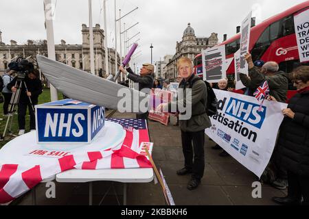 Les manifestants portant des masques de Donald Trump et Boris Johnson ainsi que les militants pour le maintien du National Health Service (NHS) sont réunis devant les chambres du Parlement pour exiger la fin de la privatisation des soins de santé au NHS à 25 novembre 2019, à Londres, en Angleterre. Les manifestants protestent contre l'inclusion du NHS dans un accord commercial entre le Royaume-Uni et les États-Unis après le Brexit. (Photo de Wiktor Szymanowicz/NurPhoto) Banque D'Images