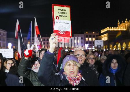 Le 1 décembre 2019, une femme détient une copie du peuple de la Constitution polonaise lors d'une manifestation anti-gouvernementale en faveur de la liberté judiciaire sur la place principale de Cracovie, en Pologne. Les manifestants se sont rassemblés dans de nombreuses villes polonaises pour exprimer leur solidarité avec le juge Pawel Juszczyszyn qui a été suspendu la semaine dernière pour avoir remis en question les réformes judiciaires du parti au pouvoir. (Photo de Beata Zawrzel/NurPhoto) Banque D'Images