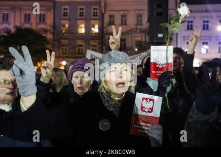 Le 1 décembre 2019, une femme détient une copie du peuple de la Constitution polonaise lors d'une manifestation anti-gouvernementale en faveur de la liberté judiciaire sur la place principale de Cracovie, en Pologne. Les manifestants se sont rassemblés dans de nombreuses villes polonaises pour exprimer leur solidarité avec le juge Pawel Juszczyszyn qui a été suspendu la semaine dernière pour avoir remis en question les réformes judiciaires du parti au pouvoir. (Photo de Beata Zawrzel/NurPhoto) Banque D'Images