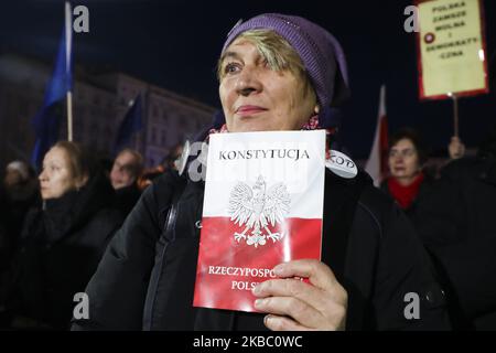 Le 1 décembre 2019, une femme détient une copie du peuple de la Constitution polonaise lors d'une manifestation anti-gouvernementale en faveur de la liberté judiciaire sur la place principale de Cracovie, en Pologne. Les manifestants se sont rassemblés dans de nombreuses villes polonaises pour exprimer leur solidarité avec le juge Pawel Juszczyszyn qui a été suspendu la semaine dernière pour avoir remis en question les réformes judiciaires du parti au pouvoir. (Photo de Beata Zawrzel/NurPhoto) Banque D'Images