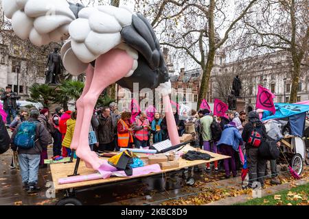 Des membres de l'organisation environnementale de la rébellion de l'extension protestent sur la place du Parlement à Londres, en Angleterre, sur 6 décembre 2019. L'organisation organise ce qu'on appelle l'opération Big Bird, où les manifestants marchent avec une statue d'un oiseau qui cache sa tête dans le sable, a pour but d'illustrer l'attitude des politiciens à l'égard des urgences environnementales. L'organisation proteste pour faire pression sur les politiciens avant les élections générales anticipées au Royaume-Uni. (Photo par Dominika Zarzycka/NurPhoto) Banque D'Images