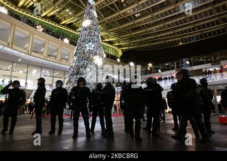 Face à face entre les gendarmes mobiles et les manifestants au pied de l'arbre de Noël illuminé dans la cour extérieure de Paris, France, le 7 décembre 2019. (Photo de Jerome Gilles/NurPhoto) Banque D'Images