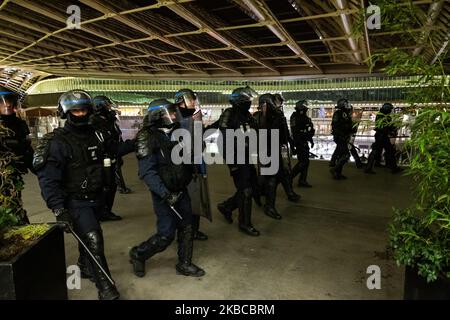 Face à face entre les gendarmes mobiles et les manifestants au pied de l'arbre de Noël illuminé dans la cour extérieure de Paris, France, le 7 décembre 2019. (Photo de Jerome Gilles/NurPhoto) Banque D'Images