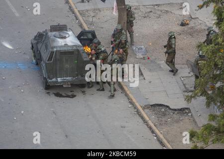 Des policiers chiliens se sont encourtés pour obtenir de l'aide après avoir été frappés par une bombe molotov lancée par des manifestants lors d'une manifestation antigouvernementale à Santiago, au Chili, en novembre. 4, 2019. (Photo de Jerez Gonzalez/NurPhoto) Banque D'Images