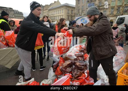 Des volontaires préparent des sacs en plastique avec des friandises de Noël lors de l'édition 2019 du « Christmas Eve - Christmas Food Handout » pour les sans-abri et les personnes dans le besoin, un événement caritatif organisé chaque année sur la place du marché principal de Cracovie. Le dimanche 15 décembre 2019, à Cracovie, dans la petite Pologne Voïvodeship, Pologne. (Photo par Artur Widak/NurPhoto) Banque D'Images