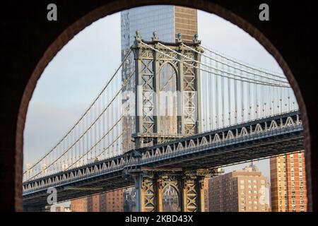 Vue en début de matinée sur le légendaire Manhattan Bridge depuis le quartier de Dumbo à Brooklyn, New York, États-Unis, le 14 novembre 2019. Le long pont suspendu de 448m. Est un point de repère de la ville de New York, une attraction touristique, traversant East River et reliant Lower Manhattan au centre-ville de Brooklyn. Le pont en fer métallique est actif avec la circulation, 7 voies de route et 4 voies de train pour le métro et les bicyclettes. Il a été ouvert à la circulation en 1909, construit par Phoenix Bridge Company et conçu par Leon Moisseiff. (Photo de Nicolas Economou/NurPhoto) Banque D'Images