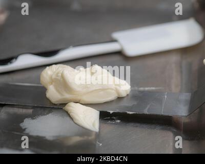 chef pâtissier concepteur de gâteaux préparant un cheesecake blanc bleu dans un laboratoire de cuisine Banque D'Images