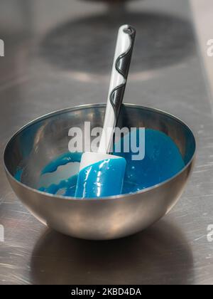 chef pâtissier concepteur de gâteaux préparant un cheesecake blanc bleu dans un laboratoire de cuisine Banque D'Images