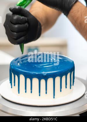 chef pâtissier concepteur de gâteaux préparant un cheesecake blanc bleu dans un laboratoire de cuisine Banque D'Images