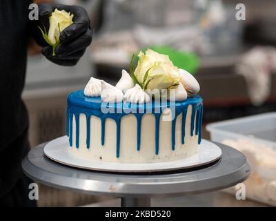 chef pâtissier concepteur de gâteaux préparant un cheesecake blanc bleu dans un laboratoire de cuisine Banque D'Images