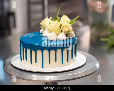 chef pâtissier concepteur de gâteaux préparant un cheesecake blanc bleu dans un laboratoire de cuisine Banque D'Images