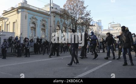 Les militants des mouvements ukrainiens d'extrême droite lancent des objets vers la police lors des affrontements qui ont opposé des ouvriers agricoles à la réforme agraire à Kiev, en Ukraine, au 17 décembre 2019. Des dizaines de militants d'extrême-droite se sont opposés à la police devant le Parlement ukrainien alors que des manifestants protestaient pacifiquement contre une éventuelle loi sur le marché foncier adoptée par les législateurs de la Verkhovna Rada. En novembre 2019, le Parlement a adopté en première lecture un projet de loi du gouvernement sur la modification de certains actes législatifs de l'Ukraine concernant le renouvellement des terres agricoles, qui lancera le marché de la vente de terres Banque D'Images