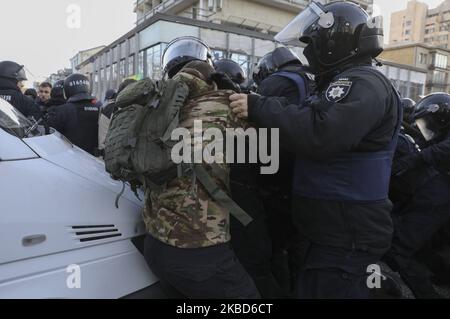 La police a emprisonné des militants des mouvements d’extrême droite lors de cette bagarre, lors d’une manifestation des ouvriers agricoles contre la réforme agraire à Kiev, en Ukraine, au 17 décembre 2019. Des dizaines de militants d'extrême-droite se sont opposés à la police devant le Parlement ukrainien alors que des manifestants protestaient pacifiquement contre une éventuelle loi sur le marché foncier adoptée par les législateurs de la Verkhovna Rada. En novembre 2019, le Parlement a adopté la première lecture d'un projet de loi du gouvernement sur la modification de certains actes législatifs de l'Ukraine concernant le renouvellement des terres agricoles, qui lancera le marché de la vente de terres en Ukraine (photo de Sergii Banque D'Images