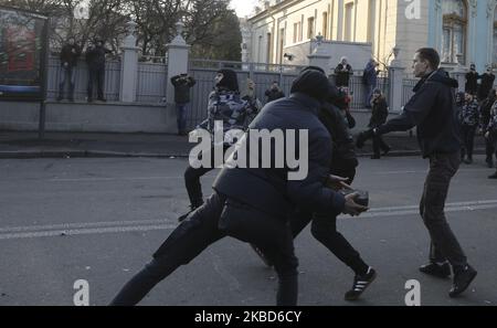 Les militants des mouvements ukrainiens d'extrême droite lancent des objets vers la police lors des affrontements qui ont opposé des ouvriers agricoles à la réforme agraire à Kiev, en Ukraine, au 17 décembre 2019. Des dizaines de militants d'extrême-droite se sont opposés à la police devant le Parlement ukrainien alors que des manifestants protestaient pacifiquement contre une éventuelle loi sur le marché foncier adoptée par les législateurs de la Verkhovna Rada. En novembre 2019, le Parlement a adopté en première lecture un projet de loi du gouvernement sur la modification de certains actes législatifs de l'Ukraine concernant le renouvellement des terres agricoles, qui lancera le marché de la vente de terres Banque D'Images