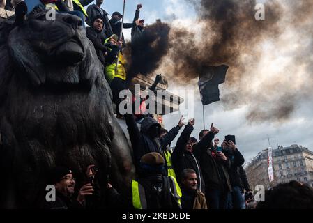 Les manifestants des Vêtes jaunes et du Bloc Noir sont rassemblés autour du lion de la statue de la République entourée d'un nuage de fumée noire mardi, 17 décembre 2019, le douzième jour du mouvement de grève contre la réforme des retraites, Alors qu'une nouvelle journée majeure de mobilisation contre la réforme a eu lieu à Paris à l'initiative des principaux syndicats français. Entre 70 000 et 350 000 personnes ont manifesté entre la place de la République et la place de la Nation contre l'introduction de la retraite ponctuelle et l'extension des heures de travail à 64 ans. (Photo de Samuel Boivin/NurPhoto) Banque D'Images