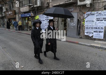 Deux jeunes Juifs se protègent de la pluie dans le quartier ultra-orthodoxe de MEA Shearim dans la ville de Jérusalem (Israël). (Photo de Joaquin Gomez Sastre/NurPhoto) Banque D'Images