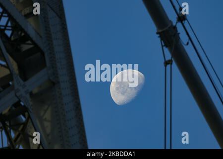 La lune à travers le pont de Williamsburg, un pont suspendu dans la ville de New York en face de l'East River, reliant le Lower East Manhattan au quartier de Williamsburg à Brooklyn, à Broadway. Le Luna illuminant, le satellite naturel de la terre en orbite, comme vu à la phase gébare, lunaire calendrier, avec 76% visible. NYC, Etats-Unis - 17 novembre 2019 (photo de Nicolas Economou/NurPhoto) Banque D'Images