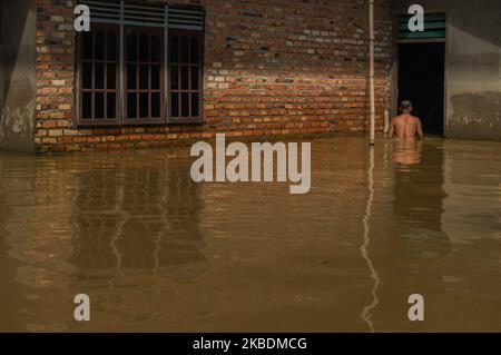 Un homme marche à travers les eaux d'inondation au village de Buluh Cina sur 31 décembre 2019 dans le district de Kampar, Riau, Indonésie. Les précipitations et le débordement de la rivière Kampar ont entraîné l'immersion des plantations d'huile de palme et des maisons des résidents. (Photo par Afrianto Silahi/NurPhoto) Banque D'Images