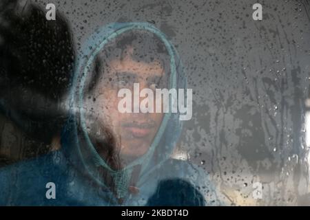 Un bédouin palestinien regardant derrière le verre lors d'une forte pluie à Gaza, sur 4 janvier 2020. (Photo de Majdi Fathi/NurPhoto) Banque D'Images