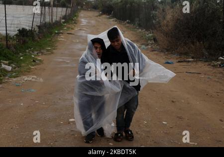 Les Palestiniens bédouins se protègent de la pluie lors de fortes pluies dans la ville de Gaza sur 4 janvier 2020. (Photo de Majdi Fathi/NurPhoto) Banque D'Images