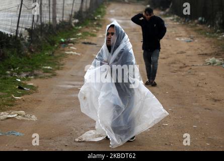 Un garçon bédouin palestinien se protège de la pluie lors de fortes pluies dans la ville de Gaza sur 4 janvier 2020. (Photo de Majdi Fathi/NurPhoto) Banque D'Images