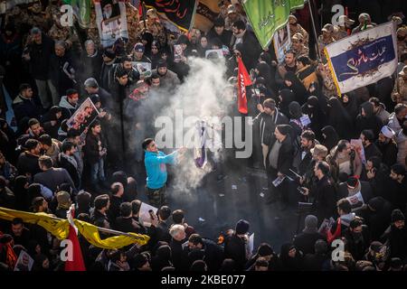 Un manifestant iranien brûle un drapeau israélien alors qu'il assistait à un enterrement de masse pour le commandant de la Force Qods DES IRG Qasem Soleimani, chef adjoint irakien-iranien des Forces de mobilisation populaire (Hashd Shaabi) commandant Jamal Ja'far Muhammad Ali Al Ibrahim, Connu par le kunya Abu Mahdi al-Muhandis et quatre autres membres du corps des Gardiens de la révolution qui ont été tués à l'aéroport de Bagdad lors d'une frappe aérienne américaine, dans le centre de Téhéran, à 6 janvier 2020. Qasem Soleimani, le chef de la Force des gardes révolutionnaires islamiques iraniens (IRGC) a été tué lors d'une frappe aérienne américaine dans l'airpo de Bagdad Banque D'Images