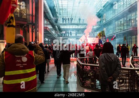 Des cheminots à la gare de Lyon ont allumé de la fumée rouge dans le hall du bâtiment BlackRock France, dans une action surprise où ils ont temporairement envahi le siège social le mardi 7 janvier 2019. Près de 200 employés en grève de la SNCF et de la RATP ont envahi le siège de Paris du gestionnaire d'actifs BlackRock pour lui remettre une « médaille de déshonneur » et exiger le retrait du projet de réforme des retraites du gouvernement. Après une assemblée générale (GA) à la gare de Lyon à Paris, les cheminots ont apporté un grand panneau avec un "medal de déshonneur" attribué à BlackRock, en référence à la légion o Banque D'Images