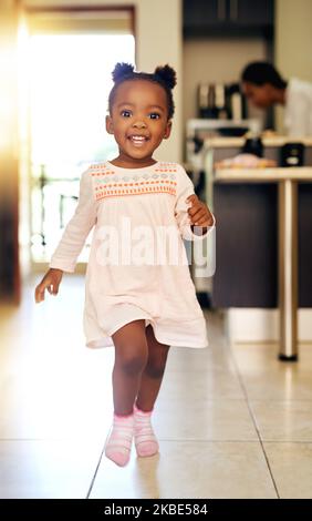 Mi sur la passerelle. Portrait en longueur d'une adorable petite fille qui marche à travers sa maison. Banque D'Images