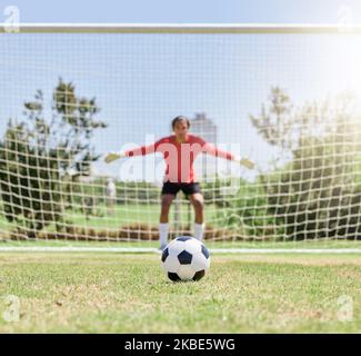 Football, sport et gardien de but en défense pour le jeu, l'exercice et l'entraînement sur le terrain de football pour arrêter le but en plein air. Athlète ou gardien de but professionnel Banque D'Images