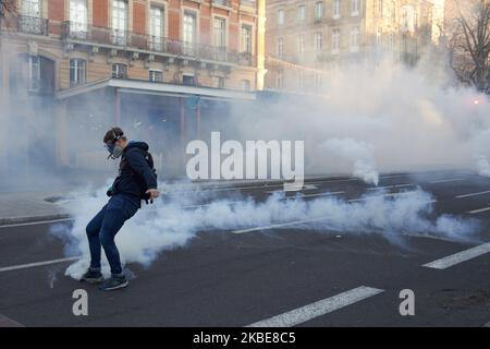 un manifestant fait un coup de pied sur une cartouche de gaz lacrymogène pour faire ricoter la police. Les manifestants de Yellow Vêtes ont manifesté pendant plus de 60 semaines consécutives dans toute la France. Plusieurs milliers de manifestants sont descendus dans les rues de Toulouse. Ils ont également protesté contre la réforme de la retraite prévue par Macron. Mais la manifestation pacifique s'est brusquement terminée, alors que la police anti-émeute a tiré des canons à eau et tiré des bidons de gaz lacrymogènes. Toulouse. France. 11 janvier 2020. (Photo d'Alain Pitton/NurPhoto) Banque D'Images