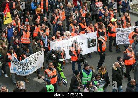 Des cheminots en grève portant une veste orange de la RATP et du RER, un opérateur de transports en commun parisien, se promisaient derrière une bannière lors d'une manifestation à Paris, sur 11 janvier 2020, dans le cadre d'une grève multisectorielle nationale contre la réforme des retraites du gouvernement français. Le pays a été frappé par 37 jours d'arrêts de train et de métro paralysants alors que les syndicats combattent les propositions, l'une des réformes emblématiques du président Emmanuel Macron. (Photo de Michel Stoupak/NurPhoto) Banque D'Images