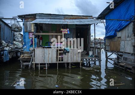 Les résidents se déplacent dans leurs foyers inondés par les marées ou les marées dans le village de Tompe, le district de Sirenja, la régence de Donggala, la province centrale de Sulawesi, en Indonésie, sur 12 janvier 2020. Inondations dues aux marées qui entrent dans les zones résidentielles, il se produit tous les 15 jours en raison d'une diminution de la surface du terrain aussi profonde que deux mètres en raison du tremblement de terre de magnitude 7,4 centré dans le village de 28 septembre 2018 alors. Les résidents locaux sont forcés de fuir vers des terrains plus élevés et de retourner à leurs maisons après que l'eau a reculé. Cette situation se passe depuis il y a un an et demi jusqu'à maintenant. (Photo de BASR Banque D'Images