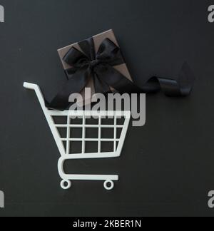 Boîte cadeau dans un panier. Soldes du Vendredi fou, cadeaux de Noël. E commerce, vente en ligne Banque D'Images
