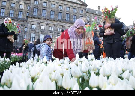 Les gens assistent à la Journée nationale des tulipes devant le Palais Royal, sur la place du Dam à 18 janvier 2020, à Amsterdam, aux pays-Bas. Aujourd'hui marque le début officiel de la saison de la tulipe avec un jardin spécial de cueillette de tulipes où les gens peuvent cueillir des tulipes gratuitement, organisé par les producteurs de tulipes hollandais, la place du Dam d'Amsterdam est remplie d'environ 200 000 tulipes. Ces tulipes sont spécialement disposées pour faire un jardin temporaire géant. Quelque 1,7 milliards de tulipes hollandaises devraient faire entrer le printemps dans les foyers du monde entier. (Photo de Paulo Amorim/NurPhoto) Banque D'Images